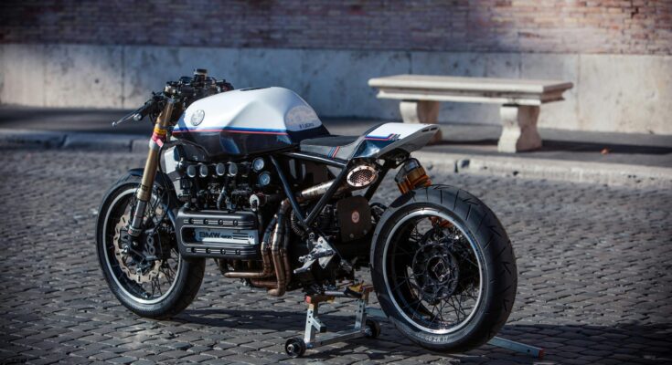 Classic vintage cafe racer motorcycle parked on cobblestone street, Rome, Italy.